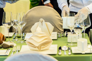Waiter decorate and setting luxury party dinner table in restaurant.