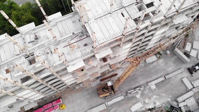 View from the drone to the construction site and the multi-apartment high-rise building during construction.