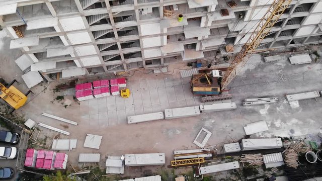 View from the drone to the construction site next to the multi-apartment high-rise building during construction.