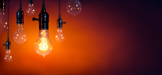 Leadership And Innovation Concept - Standing Out From The Crowd - Glowing Bulb On Among Bulbs Off 