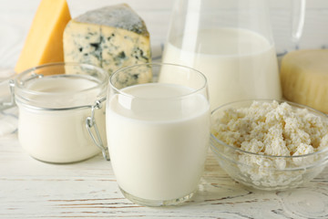 Different dairy products on white wooden background, close up