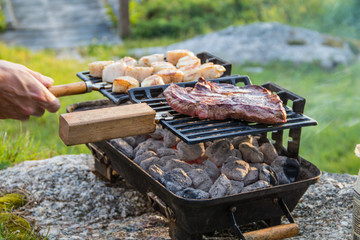 Steak and Scallops grilling on a hibachi as hot charcoal develops smoke and flames on a summer night