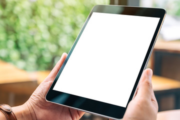 Mockup image of hands holding black tablet pc with blank white desktop screen
