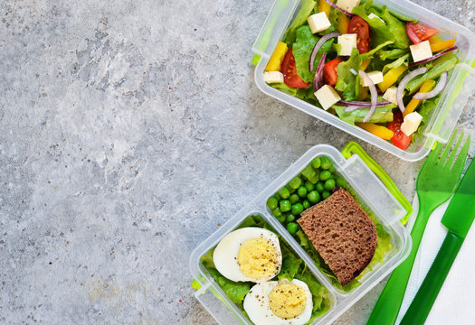 Lunch box with tomatoes, lettuce and sandwich. Top view.
