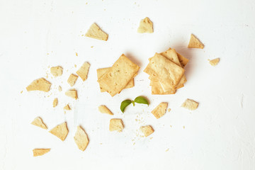 Crackers on a white table with basil leaves. Top view.
