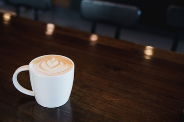 cup of coffee latte on wooden table in a cafe