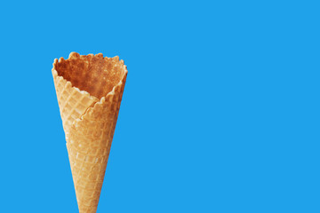 Empty ice cream waffle cone on a light blue background. Close-up.