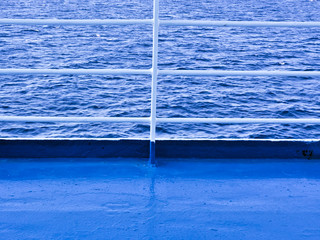 Ferry deck and railings with textured sea background.