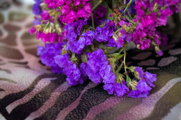 Bouquet of field and arid flowers on cloth with leopard and zebra print.