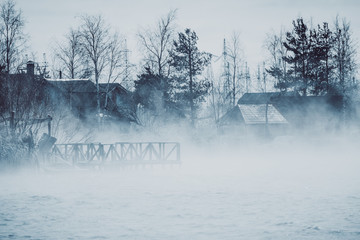 Wooden bridge in fog from water.