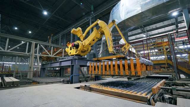 Transportation unit and a loading machine relocating bricks. Robotic Arm production line.