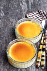 Closeup of creme brulee in glass jars on rustic wooden table
