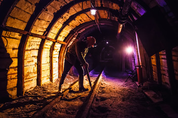 Miner working a jackhammer in a coal mine. Work in a coal mine. Portrait of a miner. Copy space. - obrazy, fototapety, plakaty