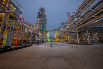 view of metal pipes of illuminated industrial plant outdoor at night 