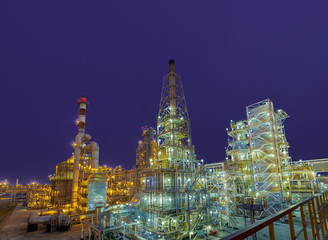 view of metal pipes of illuminated industrial plant outdoor at night 