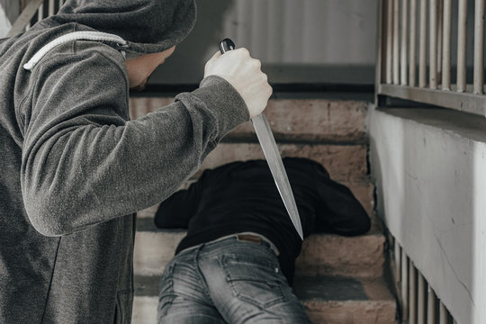 A man with a knife is trying to kill a man on the landing. topics of violence and murder. thief, killer, rapist, maniac, robbery