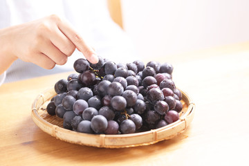 女性とテーブルの上のぶどう