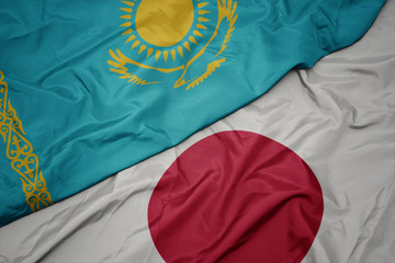 waving colorful flag of japan and national flag of kazakhstan.