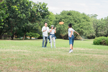 Happy children and parents playing in the park. Concept family relaxation.