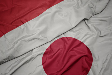waving colorful flag of japan and national flag of indonesia.