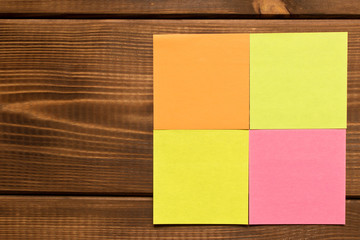 Different colored stickers on a wooden background. Empty text space