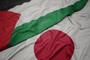 Fototapeta premium waving colorful flag of japan and national flag of palestine.