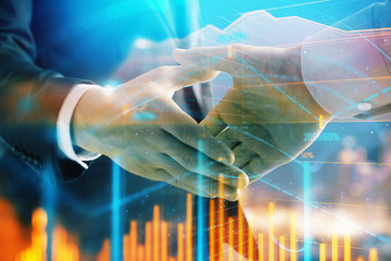 Double exposure of financial chart on cityscape background with two businessmen handshake. Concept of financial analysis and investment opportunities