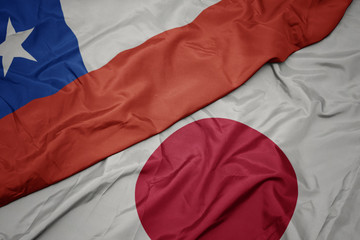 waving colorful flag of japan and national flag of chile.