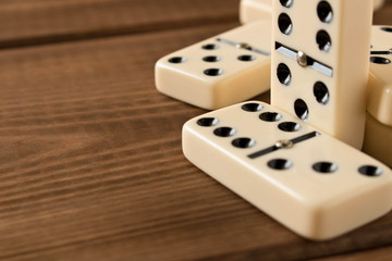 Playing dominoes on a wooden table. Domino effect.