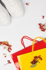 Sale and black friday concept with sneakers and red, yellow shopping bag  on white background