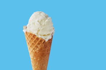 Ice cream in a waffle cone on a light blue background. Close-up.