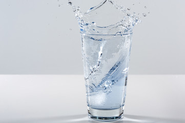 Beautiful splash of water in a glass with ice