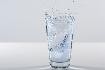 Beautiful splash of water in a glass with ice
