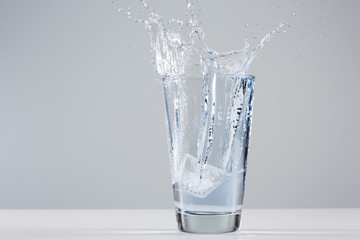 Beautiful splash of water in a glass with ice