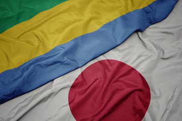 waving colorful flag of japan and national flag of gabon.