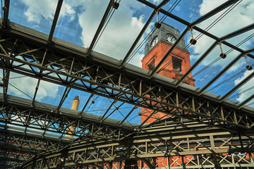 Clock tower and metal structure of the glass roof in the old brewery in Poznan.