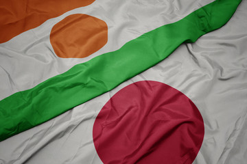 Obraz premium waving colorful flag of japan and national flag of niger.