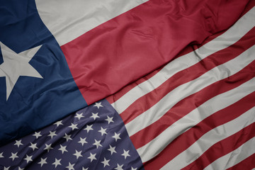 Obraz premium waving colorful flag of united states of america and flag of texas state.
