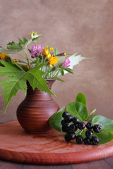 Autumn bouquet of wildflowers in a clay ceramic jug