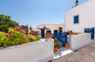 Obraz premium Chora town with white Greek house, courtyard and decorative pottery along the street, Kythira Island, Greece.