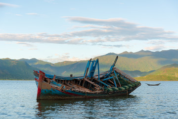 shipwreck in the bay with dramatic sky and clouds at sunrise