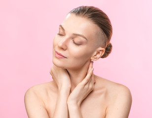 Young beauty woman with shaved temple. Studio portrait. Healthcare, skincare concept on the pink background