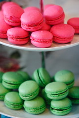 Magenta and green colored cookies of lemon and strawberry flavor accompanied by a toy rabbit.
