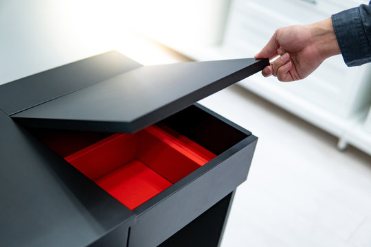 Hand opening black cosmetic table top with the red partition inside. Shopping in furniture store concept