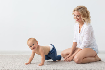 Family and parenting concept - Cute baby playing with her mother on beige carpet