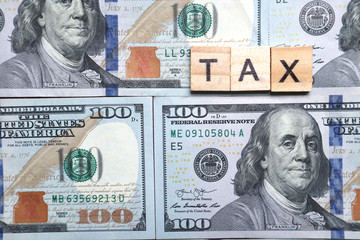 Money Investment concept,Wooden Tax text on group of 100 us dollar banknote.business profit planing for succesful
