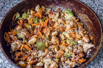 meat broccoli carrots onions garlic with sesame seeds all together in a pan.