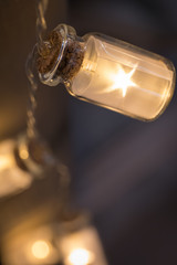 Decorative cord with glass jars with lighting in the form of an asterisk.