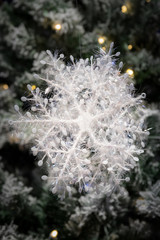 Christmas decorations in the shape of a large ice crystal with twinkle lights in the background.