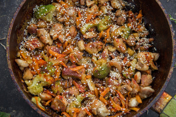 meat broccoli carrots onions garlic with sesame seeds all together in a pan.